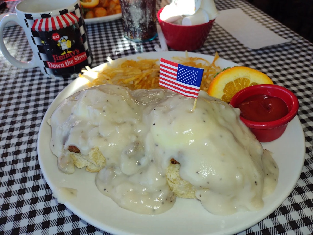 Country Benedict with sausage gravy, hash browns and an orange slice