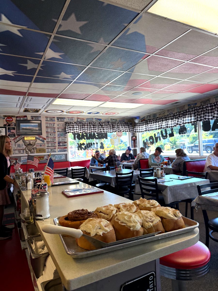 Fresh frosted cinnamon rolls on the counter under Jimmy's American flag ceiling